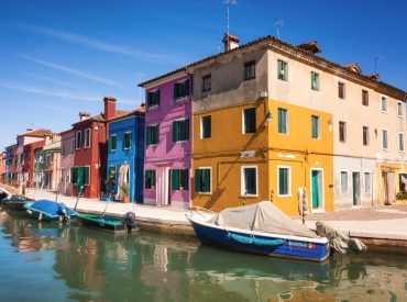 Colorful buildings and multiple boats in the canal in Venice, Italy